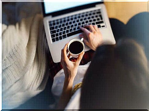 A woman with her coffee on her computer