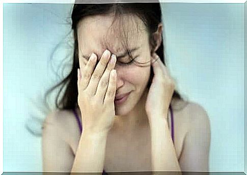 A woman hides her face with her hand