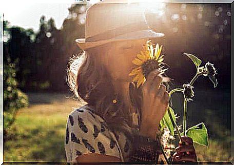 A woman smelling a flower. 