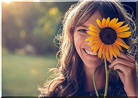 chica-sonriendo-con-un-girasol-en-la-cara